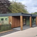 Modular School Building in Green Cladding and Timber